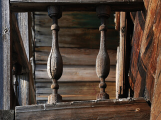 a close-up of intricately carved wooden balusters in a rustic, aged structure