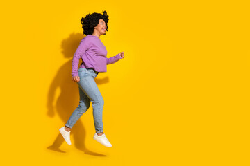 Full length photo of pretty young woman run jump empty space isolated on yellow color background