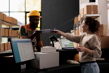 African american employee showing papers with clients orders to warehouse supervisor, dicussing...