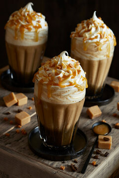 Three fresh caramel lattes, with cream topping, salted caramel sauce and toffee pieces