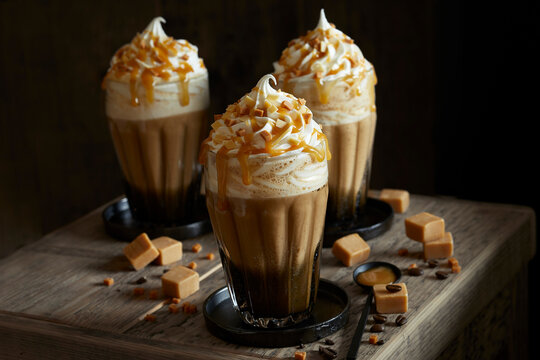 Three fresh caramel lattes, with cream topping, salted caramel sauce and toffee pieces