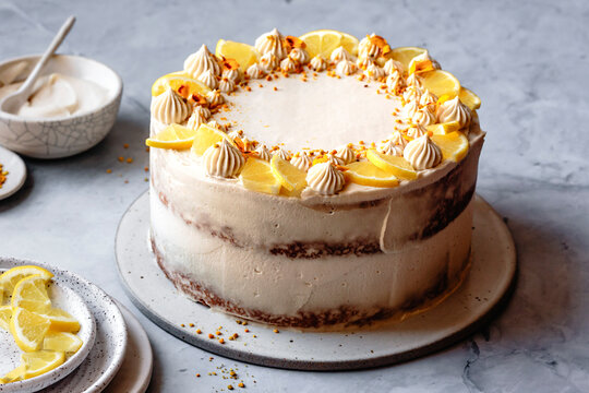 A beautifully decorated lemon layer cake on a marble background