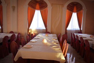 an empty hall is a classic restaurant with curtains white tablecloths and Romanesque decor. High quality photo