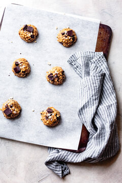 Oatmeal chocolate chip cookie dough scoops on a cookie sheet