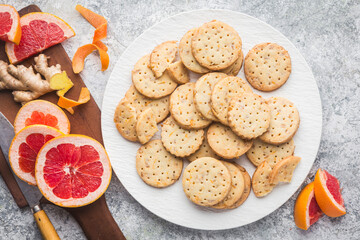 A white plate piled high with homemade ginger and grapefruit shortbread cookies on a custom grey background.