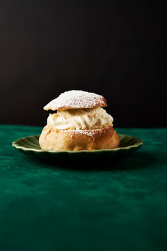Semla Buns with Cream and Icing Sugar on a green surface