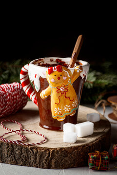 A cup of hot chocolate placed at the center of a charming Christmas scene, surrounded by decorations, evoking the magical atmosphere of the holidays