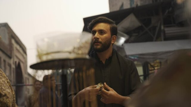 Handsome Pakistani Man bargain on the Street Market Bazaar in Lahore Walled City, Pakistan. Muslim Traditionally weared