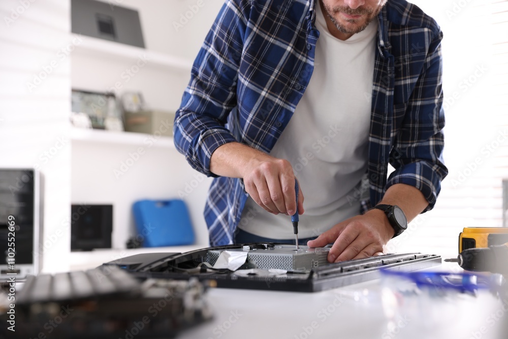 Poster man fixing computer monitor at white table, closeup