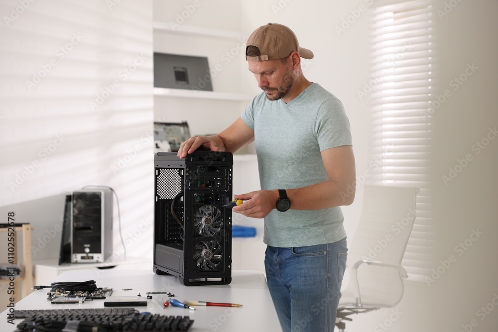 Poster man assembling new computer at white table