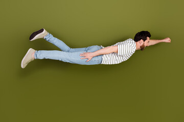 Photo of funny cheerful crazy man wear stylish clothes fly air levitate isolated on khaki color...
