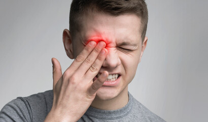 Upset man suffering from strong eye pain. Healthcare concept, panorama