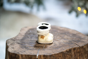 white santa claus boots and toys on tree stump in winter snowy forest . Merry Christmas and happy new year