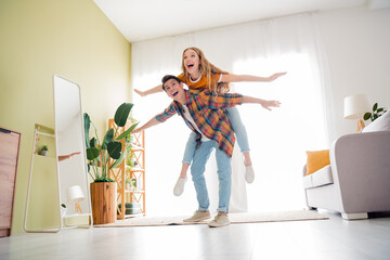 Joyful young couple enjoying playful bonding time at home in a cozy living room during daylight