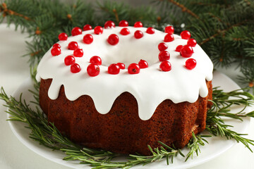 Beautifully decorated Christmas cake and fir branches on white table, closeup