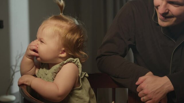 Small one-year-old child, sweetly covers his nose with his hand and makes a face of disgust at the smell of farts and dirty diapers.