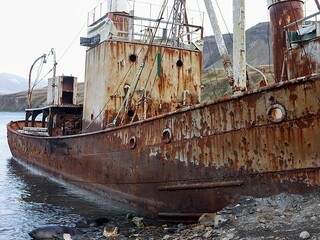 Rusted Fishing Boat on Rocky Shoreline