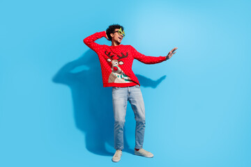 Full size photo of pretty young male dance discotheque wear red christmas sweater masquerade theme party on blue color background