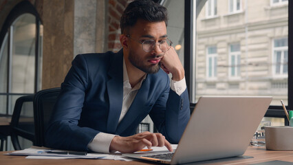 Arabian Indian tired exhausted businessman male guy entrepreneur worker manager at office desk sad...
