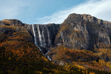 A Majestic Waterfall Cascading Down Autumn Colored Mountains Creating a Breathtaking Scene