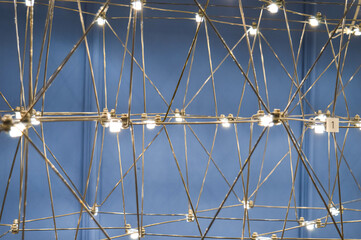abstract background is a metal structure made of thin rods with light bulbs in a geometric...