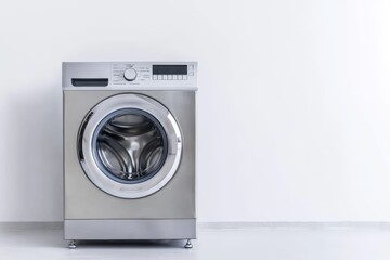 A silver washing machine with a white wall behind it