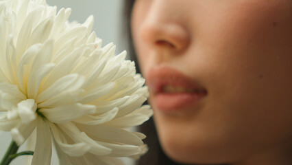 Extreme close up Asian woman chinese girl unrecognizable female smelling flower blossom fresh aroma fragrance natural organic cosmetics skin care cosmetology beauty smell floral perfume health medical
