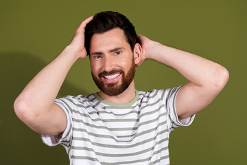 Photo of cheerful handsome positive man wear striped stylish clothes clean hair isolated on khaki color background