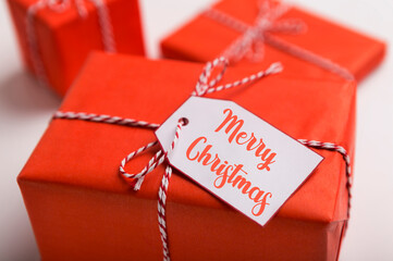 Merry Christmas concept. Wrapped gift boxes with creative label on blurred background