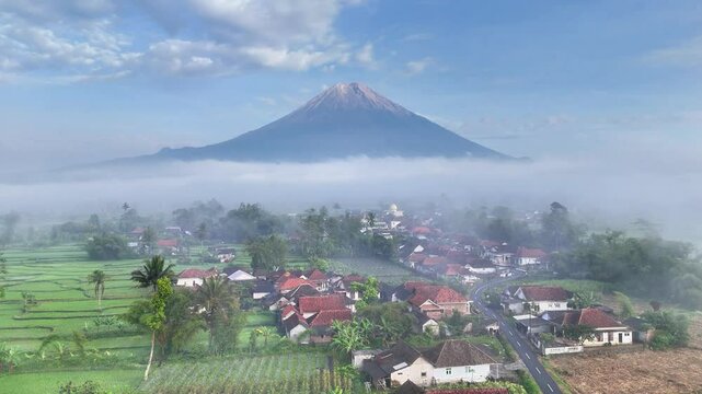 aerial view of mount semeru in east java indonesia with rural landscape and agricultural land in a foggy atmosphere.