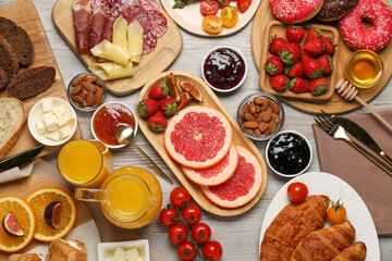 Different tasty food served for brunch on wooden table, flat lay