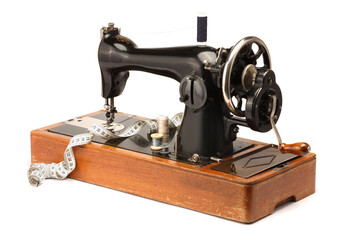 Sewing machine, measuring tape and spools of threads isolated on white