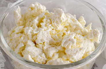 Closeup freshly made cottage cheese in glass bowl
