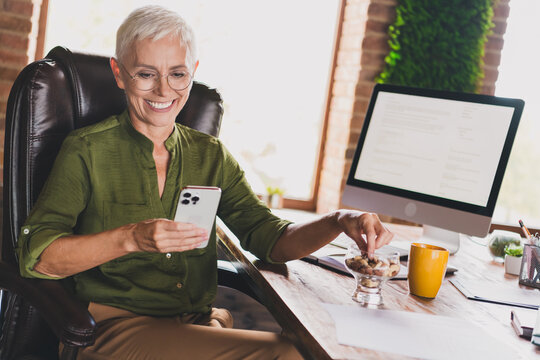 Photo of successful professional lady banker dressed shirt eyewear healthy snack workplace workstation loft interior indoors