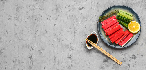 Plate with tasty crab sticks and sauce on grunge background © Pixel-Shot