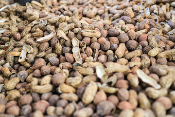 Image shows a close-up of numerous peanuts, both shelled and unshelled, creating a textured surface. A Close-Up View of a Pile of Shelled and Unshelled Peanuts.