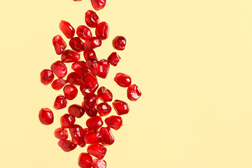 Fresh pomegranate with seeds on yellow background