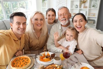 Happy family taking selfie at festive table on Thanksgiving Day