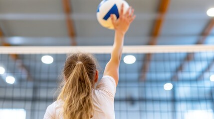 A dynamic angle captures a girl leaping to hit a volleyball on an indoor court, embodying the enthusiasm and energy of competitive indoor sports.
