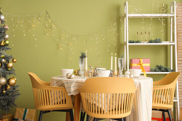 Festive table setting with Christmas decorations, reindeers and burning candles in dining room