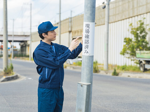 鑑識、工事、男性、事故、現場検証、確認、チェック、保険、スタッフ、交通、道路、職員、警察、警官、当て逃げ、証拠、捜査、事件、ひき逃げ、現場、検証、電柱、公共物、自損、器物損壊、賠償、修理、作業員、建設、設置、産業、歩道、安全、危険、曲がる、衝突、屋外、仕事、職業、日本人、作業服、設備、行政、通報、都市、街、調査、目撃者、張り紙、人物