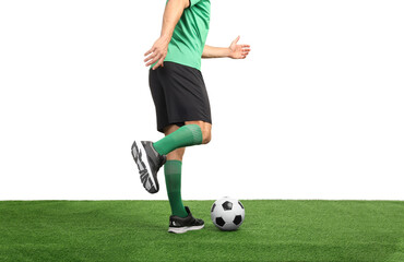 Obraz premium Man playing football with soccer ball on artificial grass against white background, closeup