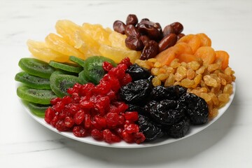 Mix of different dried fruits on white marble table, closeup