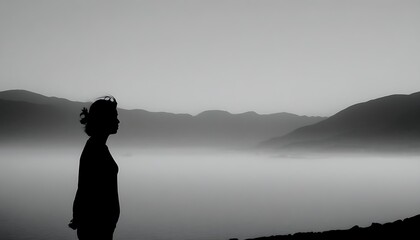 A silhouette of a person in a valley, exhibiting peace and contemplation