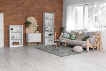 Chest of drawers, shelving units, coffee table and sofa in interior of living room