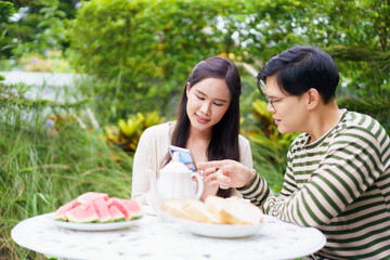 Excited Asian man and woman expressing their happy and satisfied emotion after got a message on smartphone.