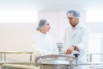 Quality control officer are examining in beverage manufacturing factory.