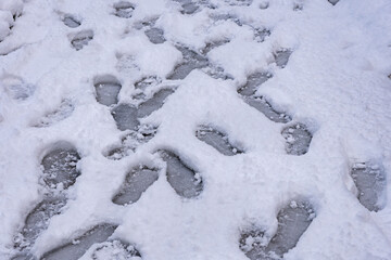 footprints on the snow piled up on the city streets.