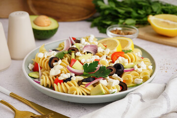 Plate with traditional pasta salad on table