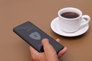 Man's hand holding smartphone with lock display on screen